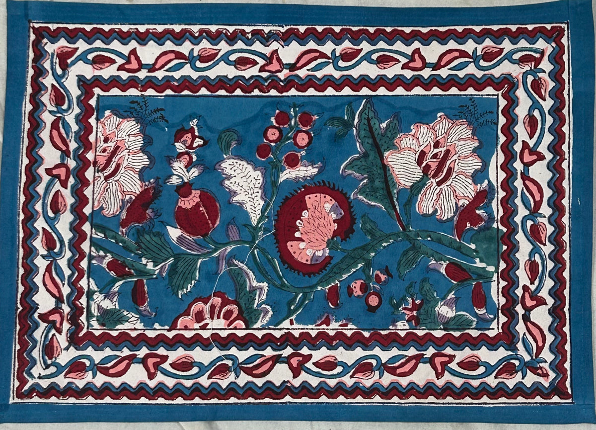 Hand block printed pomegranate and floral table mat with teal background and burgundy border